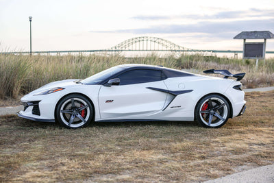 2023 Corvette C8 Z06 with custom concave rims and carbon flash wheels in a scenic outdoor setting.
