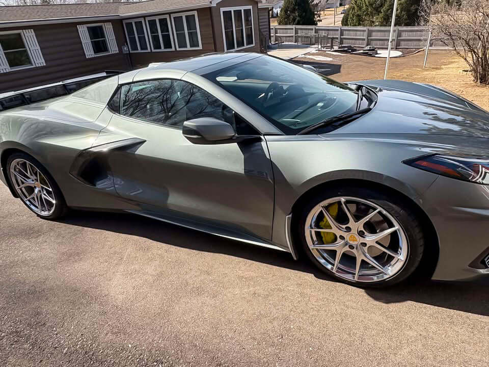 2022 Corvette C8 Z51 HTC in gray with polished aluminum rims and custom wheels, parked outside.