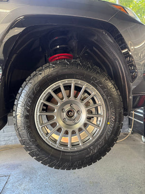 Close-up of the RVRN RV-MT117 matte gunmetal wheel and Toyo Open Country A/T tire on a 2024 Toyota RAV4 Prime