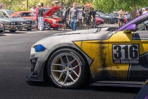 Close-up of the RVRN RV-MR08 front wheel with pearl white spokes and yellow barrel on a liveried 2019 Ford Mustang GT Premium