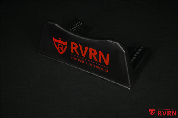 Angled view of the black RVRN Custom Forged Wheels display plaque with red RVRN logo and brand slogan.