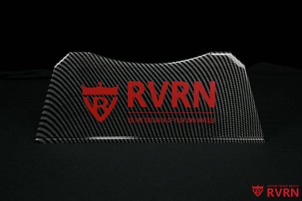 Front view of the RVRN Custom Forged Wheels display plaque with carbon-fiber-pattern finish, red logo, and brand slogan.