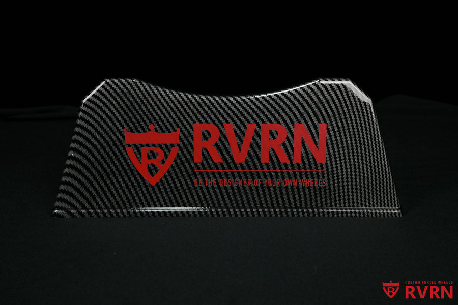 Front view of the RVRN Custom Forged Wheels display plaque with carbon-fiber-pattern finish, red logo, and brand slogan.