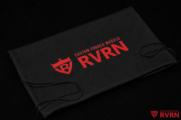 Folded black RVRN Custom Forged Wheels storage bags with red branding and drawstring closures.