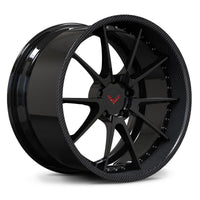 Corvette C8 custom carbon wheels, RVRN RV-DC02 2-piece forged wheel featuring gloss black face with real carbon fiber lip and Corvette crossed flags logo center cap angled view.