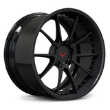 Corvette C8 custom carbon wheels, RVRN RV-DC02 2-piece forged wheel featuring gloss black face with real carbon fiber lip and Corvette crossed flags logo center cap angled view.