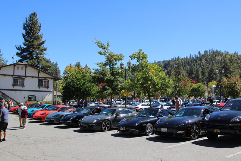 Porsche enthusiasts gathering under light rain during the event.