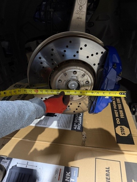 Close-up technical review of G90 M5 steel brake clearance margins conducted by RVRN engineering team for fitment resolution.