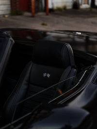 Interior shot of a 1973 C3 Corvette featuring a sleek black leather seat with a distinctive emblem.