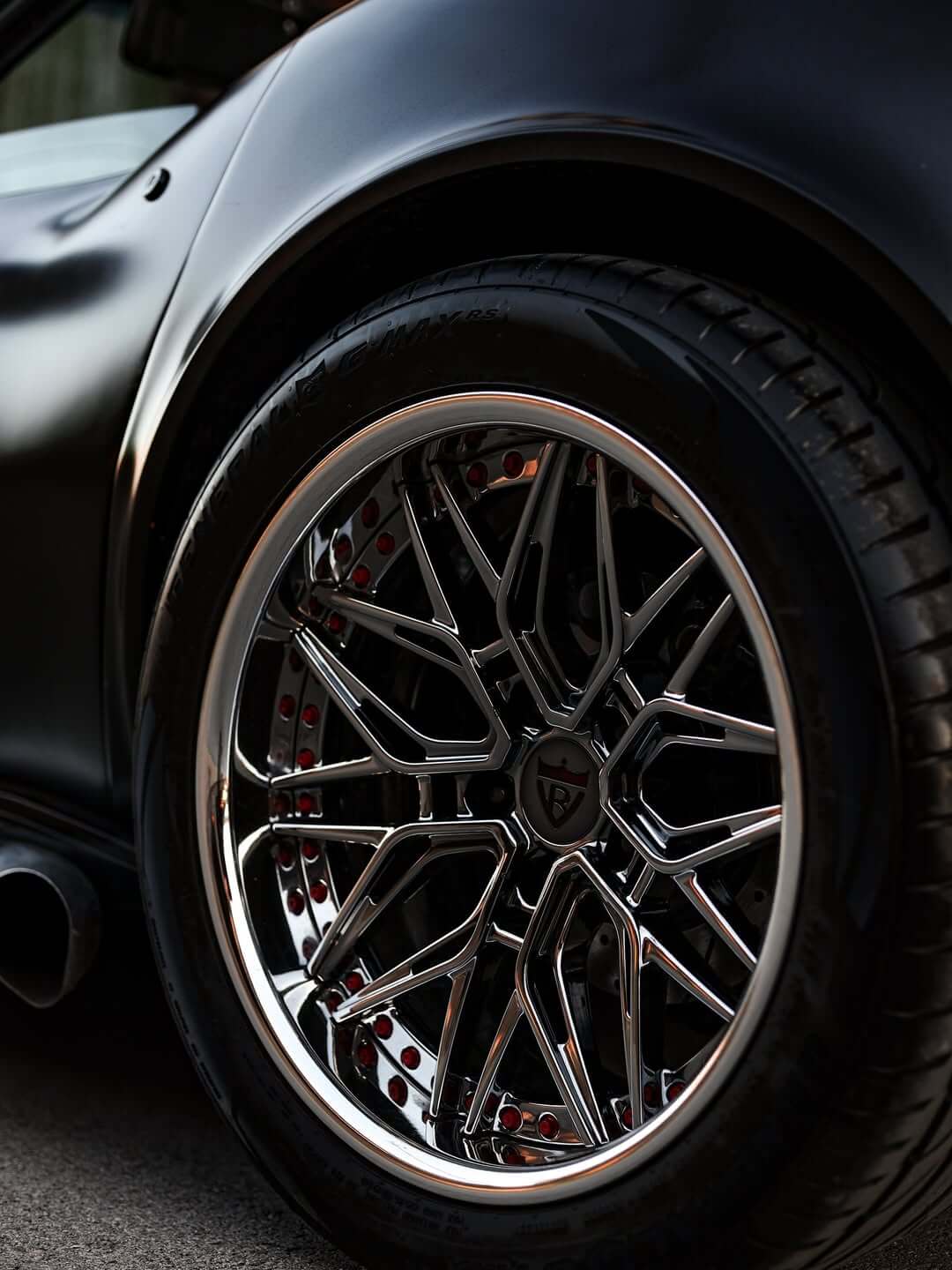 Close-up of custom chrome and red rims on a C3 Corvette featuring 18-inch aluminum wheels.