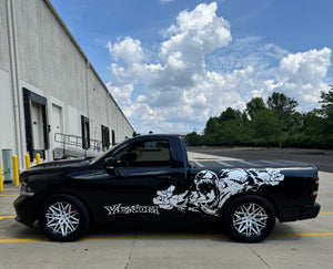 Side profile of a black 2018 Dodge Ram 1500 Sport RT on RVRN RV-C081 pearl white concave wheels beside an industrial warehouse
