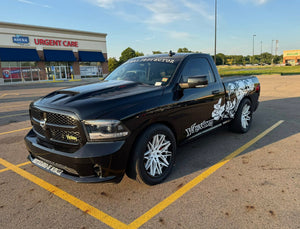 Front view of a black 2018 Dodge Ram 1500 Sport RT on RVRN RV-C081 pearl white concave wheels outside an urgent care plaza