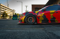 Dodge Charger with custom forged wheels, deep dish black rims, and striking camouflage wrap on 20-inch wheels.