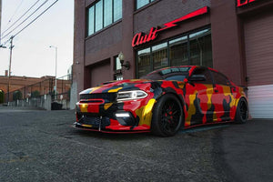 Custom Dodge Charger with a vibrant camouflage wrap and deep dish black rims, showcasing style and performance.