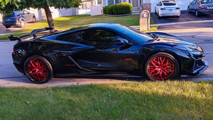 Side profile of a black 2024 Corvette C8 Z06 with rear wing on RVRN RV-T081 deep dish forged wheels with crystal burgundy spokes