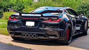 Rear three-quarter view of a black 2024 Corvette C8 Z06 with large rear wing on RVRN RV-T081 deep dish crystal burgundy forged wheels