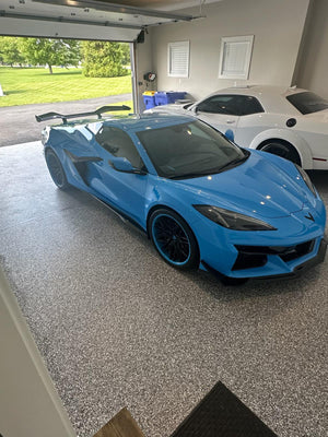 2025 Corvette Z06 in rapid blue with forged RVRN RV-T081 wheels, showcasing deep concave design in a modern garage.