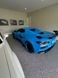 2025 Rapid Blue Corvette Z06 with RVRN forged wheels showcasing deep concave design in a stylish garage setting.