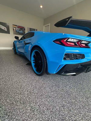 2025 rapid blue Corvette Z06 with RVRN forged wheels featuring deep concave design in a modern garage setting.