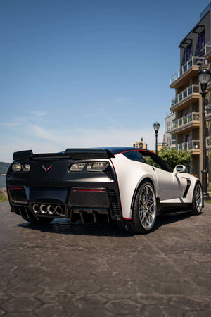 Rear three-quarter view of a white 2015 Corvette C7 Z06 on RVRN RV-T081 polished aluminum deep dish wheels along a waterfront promenade