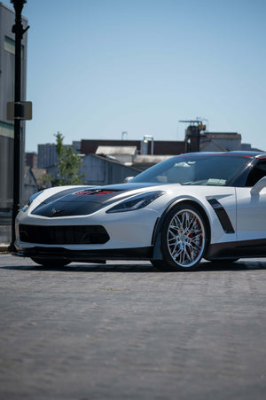 Side-front view of a white 2015 Corvette C7 Z06 on RVRN RV-T081 polished aluminum deep dish wheels on an urban street