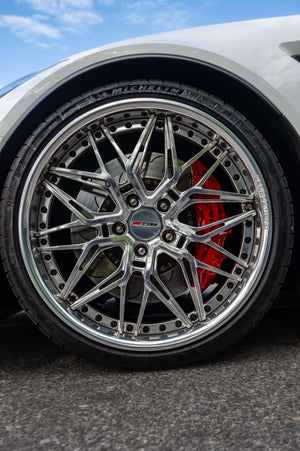 Close-up of the RVRN RV-T081 polished aluminum deep dish wheel with chrome screws on a white 2015 Corvette C7 Z06
